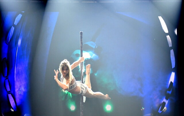 Showact beim Sömmerdaer Sportlerball Artistin während einer Pole-Dance-Showeinlage auf der Bühne beim Sportlerball, im Hintergrund farbige Lichtprojektionen.
