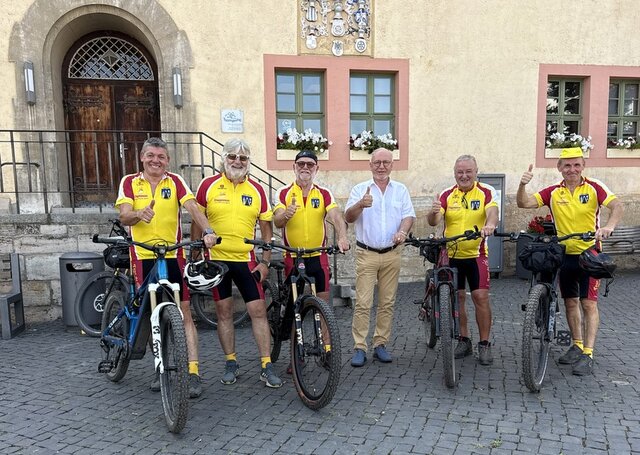 Die Radgruppe um Winfried Bergmann (2. v. l.) freut sich auf die Tour. Bürgermeister Ralf Hauboldt (4. v. l.) wird am Samstag den Startschuss geben. Fünf Radfahrer in gelben Trikots stehen in einer Reihe vor dem Treppenaufgang des Rathauses in Sömmerda und heben den Daumen. Vier der Radfahrer haben neben sich ihr Fahrrad stehen. In der Mitte der Reihe steht Bürgermeister Ralf Hauboldt.