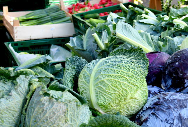 Zu sehen sind eine Kiste mit Wirsing- und Weißkrautköpfen. In weiteren Kisten liegen Blumenkohlköpfe, Gurken, Radieschen und Frühlingszwiebeln.